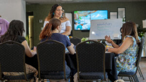 Five girls sitting around table talking about future plans.