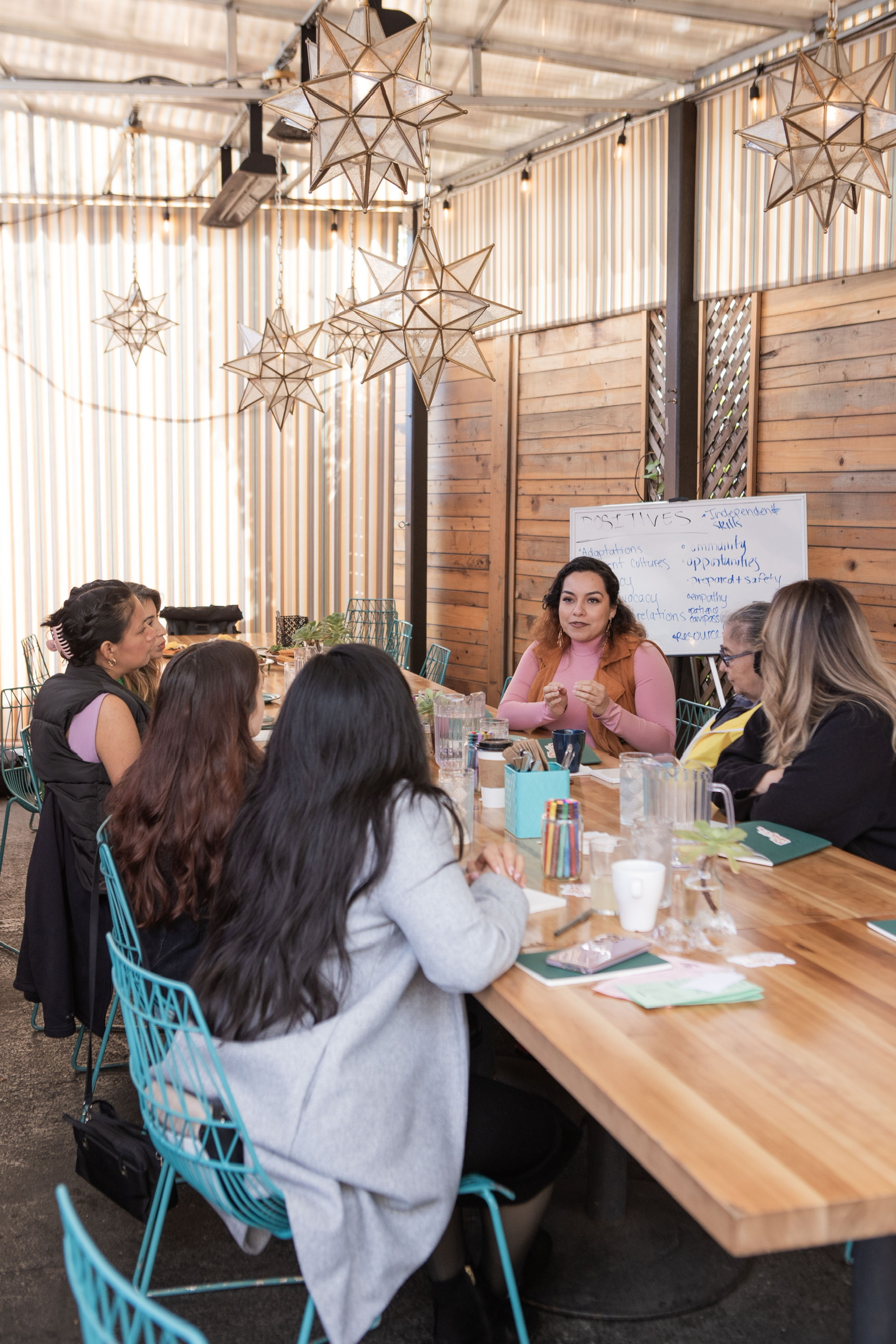 Seven girls discussing future events at long table.